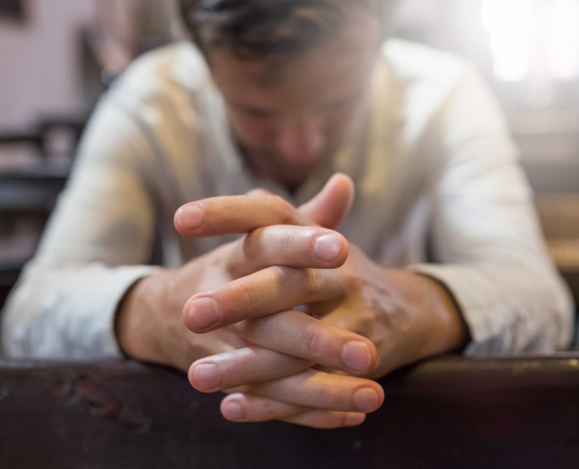 man praying in church.